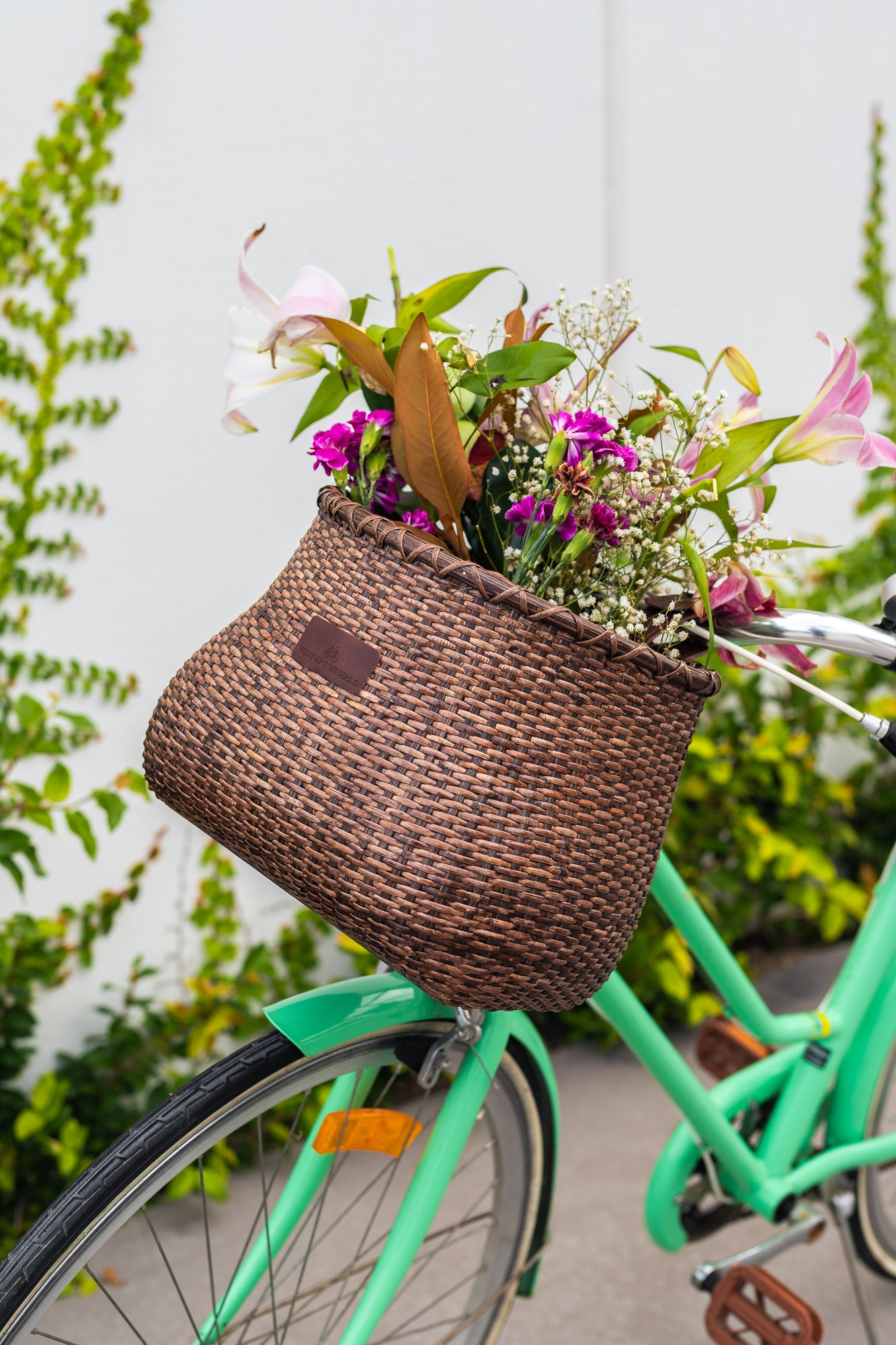 Bicycle Basket on green bike full of beautiful flowers