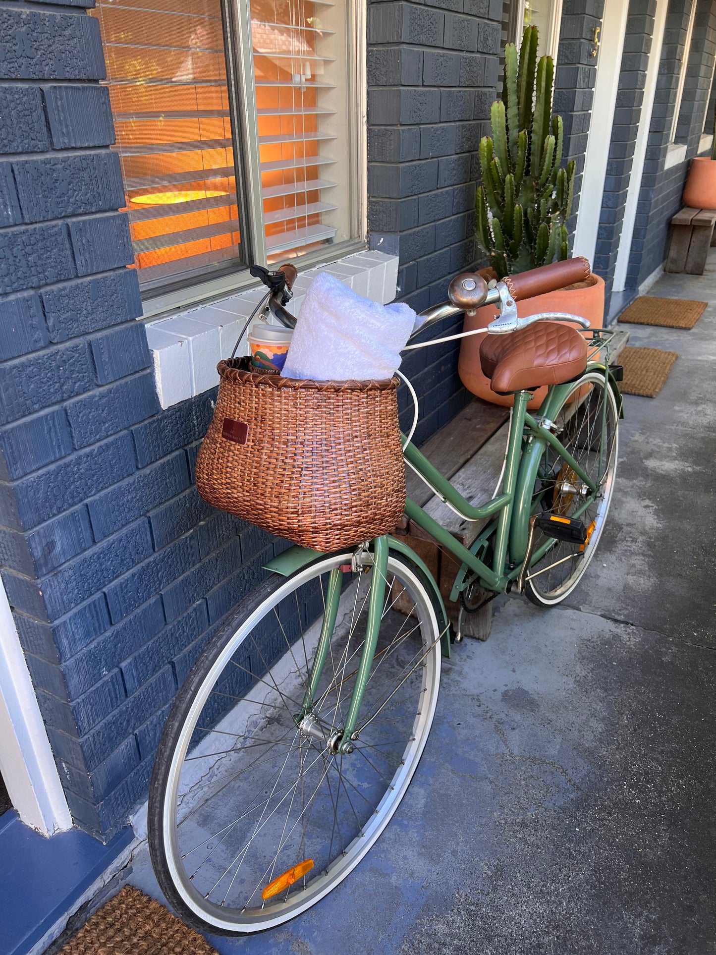 Bike Basket holding a towel and coffee outside a beach hotel