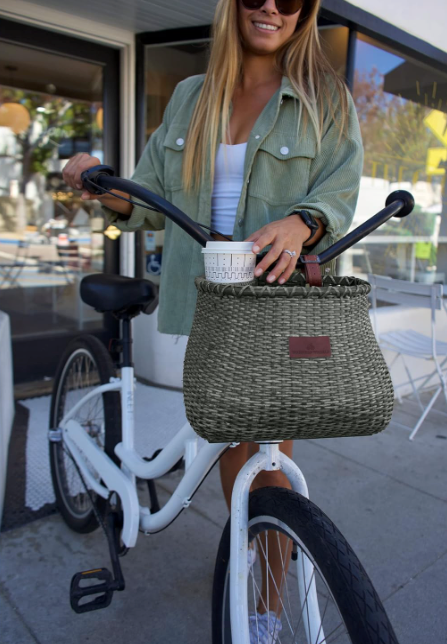 Bike Basket with a take out coffee cup being placed inside the holder outside a coffee shop